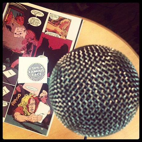 Still life photograph of a microphone and an open comic book.