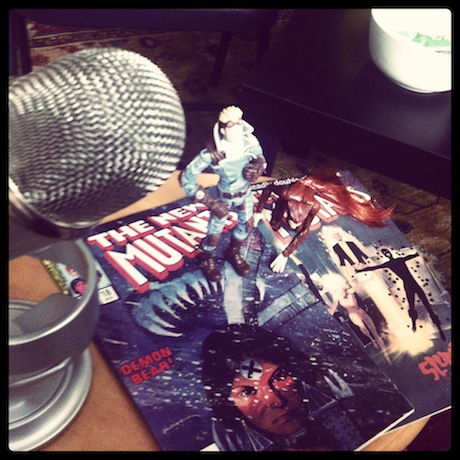 Still life photograph of a microphone and an action figure.