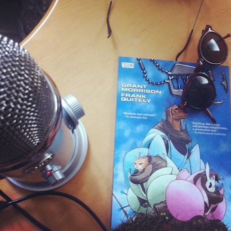 Photograph of microphone, comic book, and a pair of sunglasses.