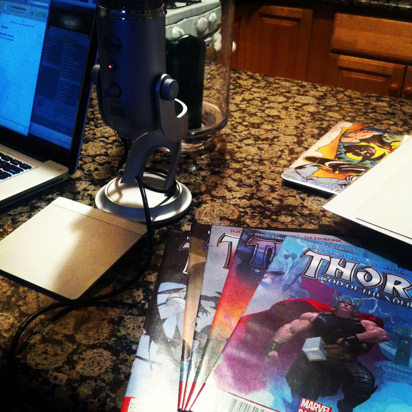 Photo of a microphone and some Thor comic books on a table.